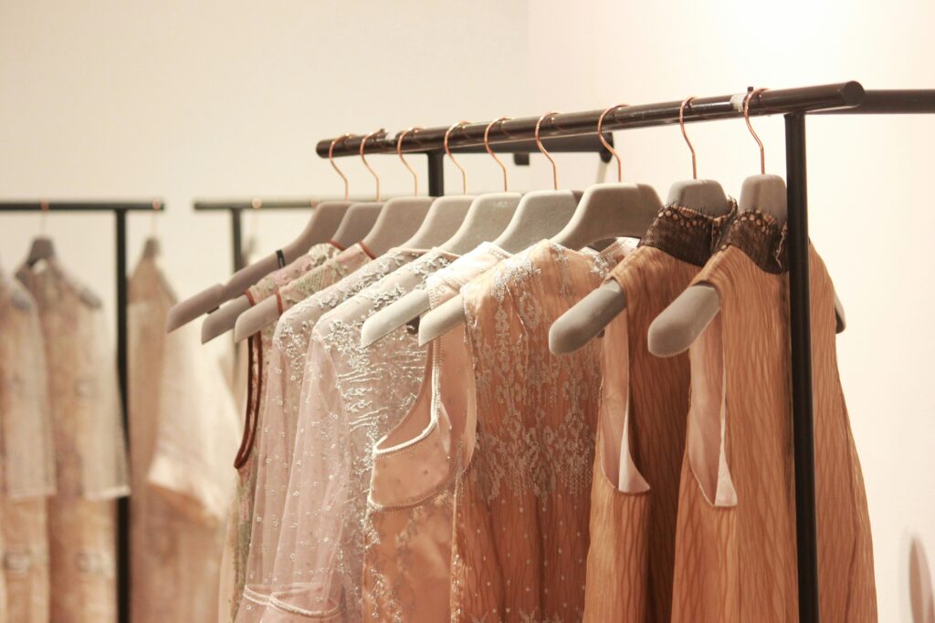 Elegant pastel dresses hanging neatly on modern clothing racks in a boutique